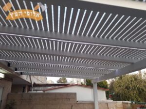 פרגולה מעץ בצבע לבן בגינה של בית פרטי בשכונת נווה עופר בתל אביב