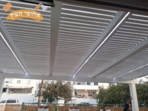 פרגולה מעץ צבוע בלבן כולל הצללה בחצר בית פרטי בחיפה בשכונת בת גלים