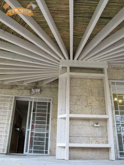 פרגולה מעץ בעיצוב אישי בצבע לבן כולל הצללה בעץ במבוק לחצר דירת גן באריאל