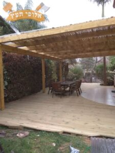 פרגולה מעץ גושני כולל הצללה בעץ במבוק לחצר בדירת גן בשכונת נווה הדר שבאבן יהודה