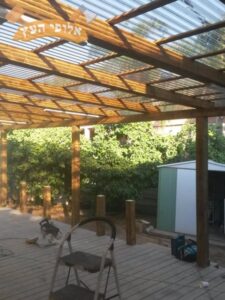 בניית פרגולה מעץ גושני כולל הצללה בחצר דירת גן באלעד