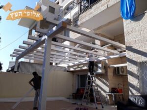 בנייה מקצועית של פרגולה בצבע לבן במרפסת בדירה בבת ים. צילום: פרגולות עץ הזית