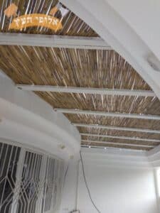 פרגולה לבנה עם הצללת במבוק מותקנת במרפסת מעוגלת בחדרה