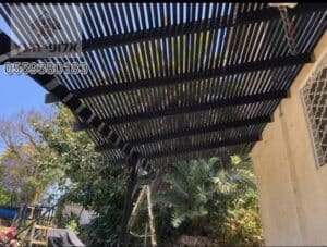 בניית פרגולה מעץ בחצר אחורית של בית בנס ציונה